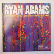 Vinyl record cover with colorful abstract design and 'Ryan Adams' text