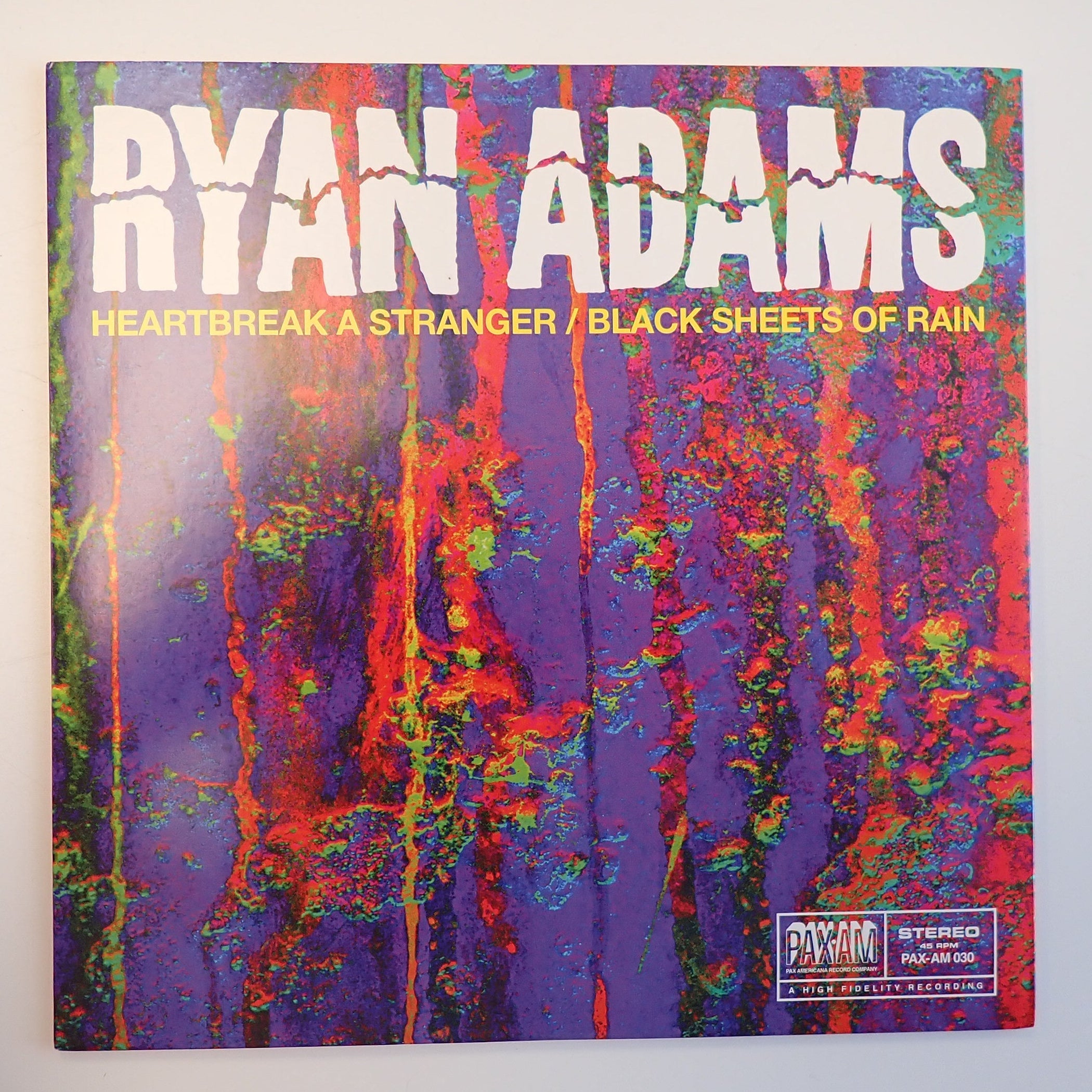 Vinyl record cover with colorful abstract design and 'Ryan Adams' text